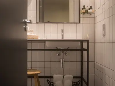 London bathroom with white wall tiles and a black geometric floor