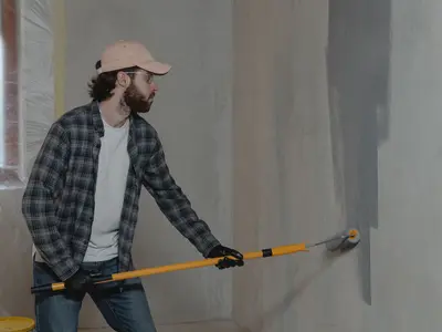 Decorator painting a wall with a roller